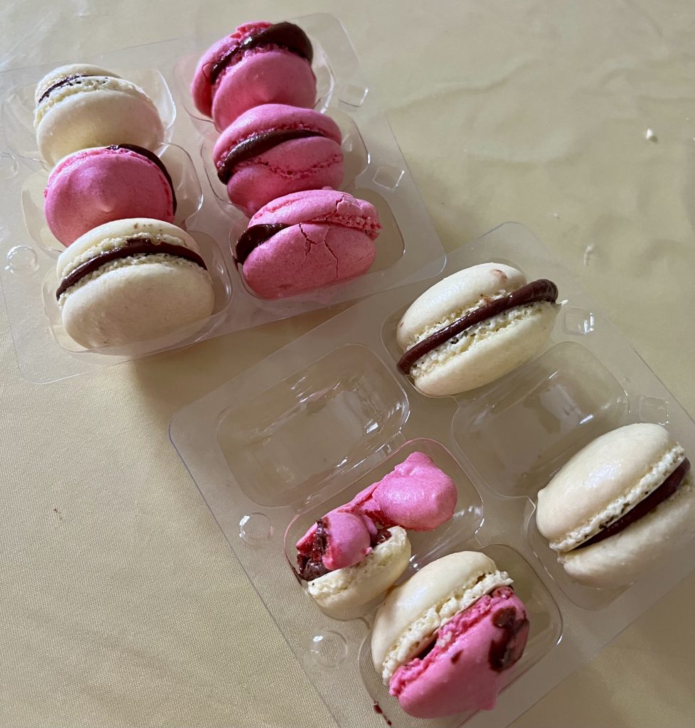 Homemade macarons packed in a small box, some already eaten
