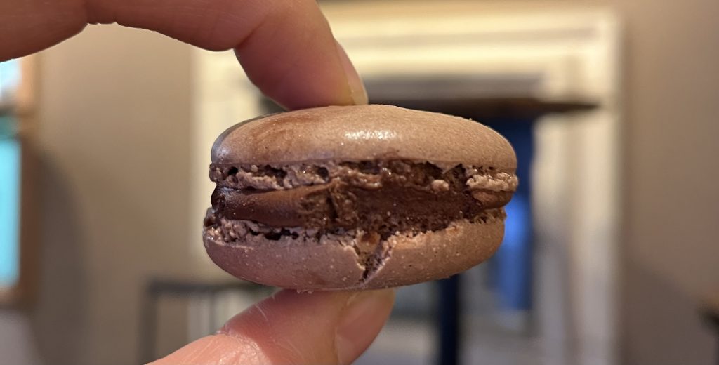 Close-up of a chocolate macaron with creamy ganache filling